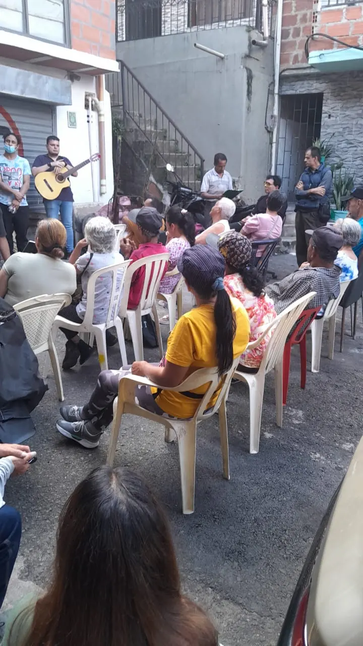 Vecinos reunidos en sillas durante una actividad musical de Decorarte
