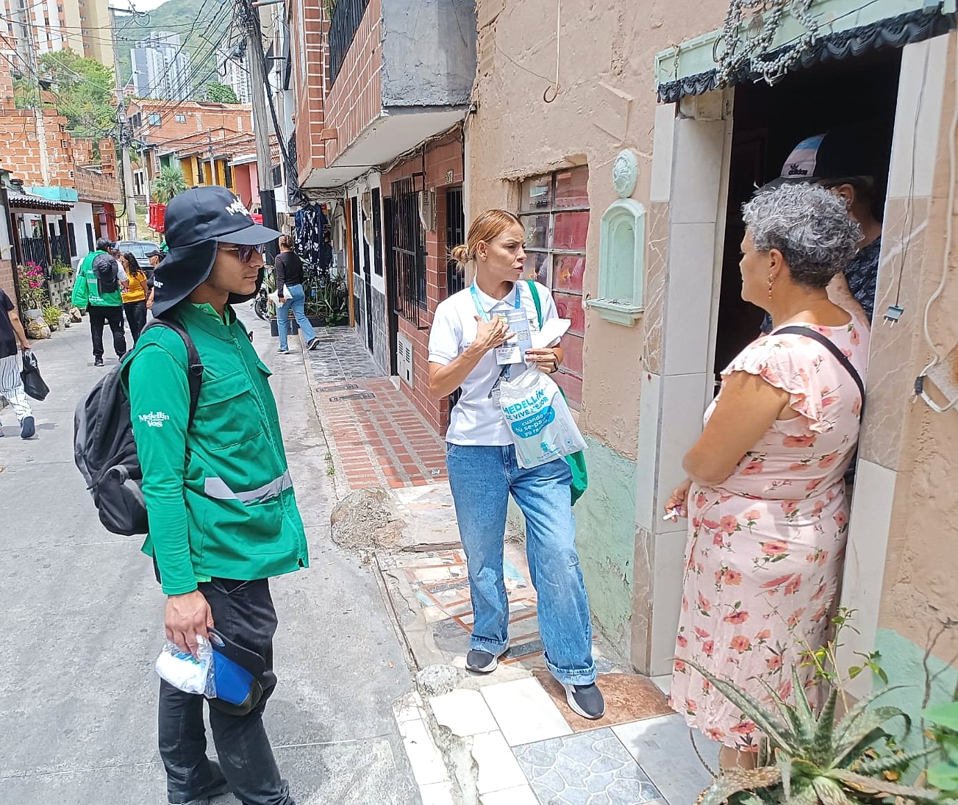 Equipo de CORASEARES conversando con una vecina en la puerta de su casa