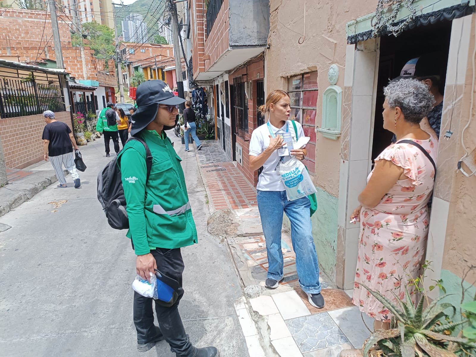 Equipo de CORASEARES conversando con una vecina en la puerta de su casa