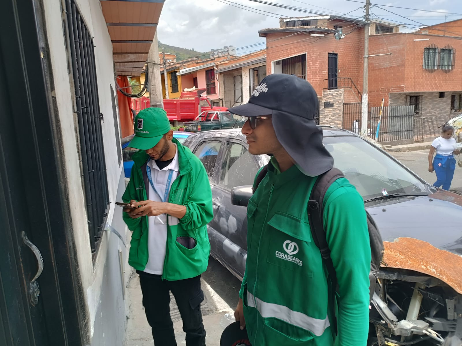 Equipo de CORASEARES en uniformes verdes durante la recolección en un barrio de Medellín